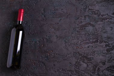 Siyah zemin üzerinde şarap şişesi olan düz kompozisyon, kopyalama alanı