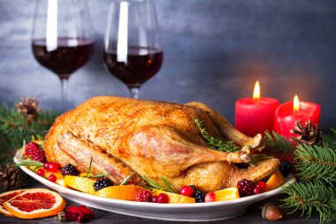 Portakallı, böğürtlenli ve otlu tam kavrulmuş ördek, bir bardak kırmızı şarap. Noel süsleri. Noel arifesi için tabak. Boşluğu kopyala