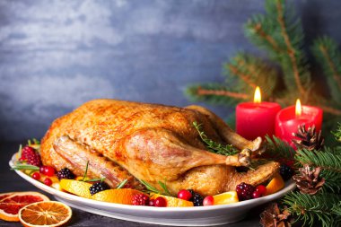 Portakallı, böğürtlenli ve otlu tam pişmiş ördek. Noel süsleri. Noel arifesi için tabak. Boşluğu kopyala