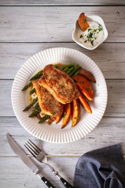Kuşkonmaz, tatlı patates ve yoğurt soslu domuz pirzolası. Tepedeki dikey resim