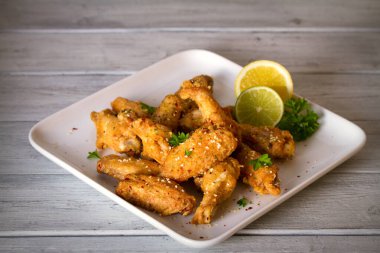 Beyaz tabakta kızarmış tavuk kanadı. Yatay resim