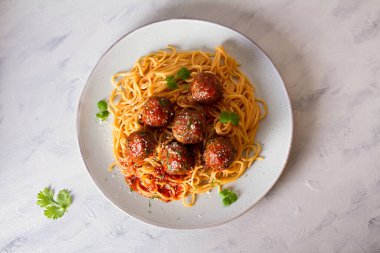 Tabakta domates soslu köfte ve makarna. Yatay görüntünün üstünde