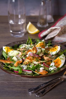 Yumurta, roka ve sebzeli füme uskumru balığı salatası. dikey resim