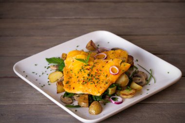 Beyaz tabakta patates, mantar ve ıspanaklı balık filetosu. yatay resim