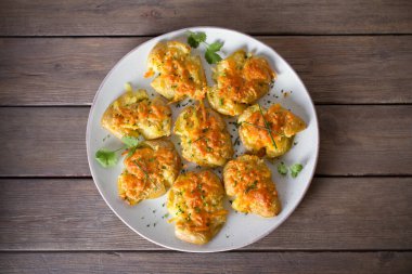 Tahta arka planda sarımsaklı tereyağlı ve peynirli yeni bebek patatesleri ezdim. Temiz yemek. Düz uzanın, başınızın üstünde