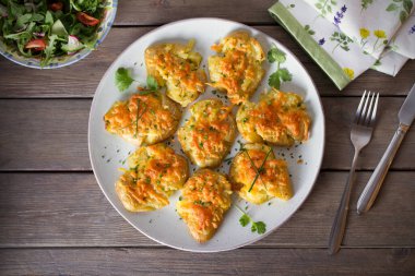 Tahta arka planda sarımsaklı tereyağlı ve peynirli yeni bebek patatesleri ezdim. Temiz yemek. Düz uzanın, başınızın üstünde