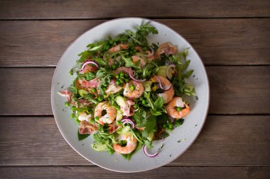 Pastırmalı karides salatası, salatalık ve ahşap arka planda turp yakın plan. Temiz yemek. Düz uzanın, başınızın üstünde