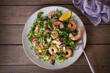 Pastırmalı karides salatası, salatalık ve ahşap arka planda turp yakın plan. Temiz yemek. Düz uzanın, başınızın üstünde