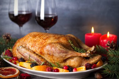 Portakallı, böğürtlenli ve otlu tam pişmiş ördek. Noel yemeği masası. Yatay fotoğraf