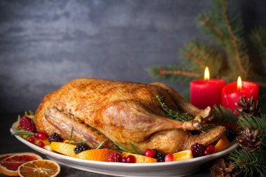 Portakallı, böğürtlenli ve otlu tam pişmiş ördek. Noel yemeği masası. Yatay fotoğraf