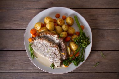 Biftek fileto, kremalı Gorgonzola peyniri sosu ve tabakta sebze. Tepede düz bir resim var.