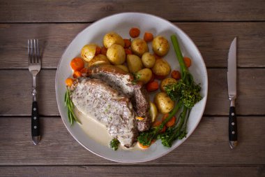 Biftek fileto, kremalı Gorgonzola peyniri sosu ve tabakta sebze. Tepede düz bir resim var.