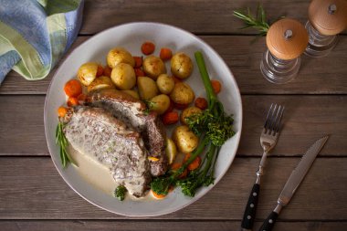 Biftek fileto, kremalı Gorgonzola peyniri sosu ve tabakta sebze. Tepede düz bir resim var.