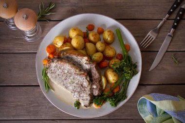 Biftek fileto, kremalı Gorgonzola peyniri sosu ve tabakta sebze. Tepede düz bir resim var.