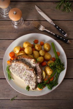 Biftek fileto, kremalı Gorgonzola peyniri sosu ve tabakta sebze. Tepede düz bir resim var.