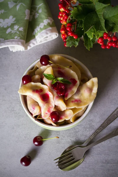 Kirazla dolu börekler. Varenyky, vareniki, pierogi, pyrohy - birçok ülkede popüler yemek. Yukarıdaki dikey fotoğraf