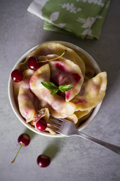 Kirazla dolu börekler. Varenyky, vareniki, pierogi, pyrohy - birçok ülkede popüler yemek. Yukarıdaki dikey fotoğraf
