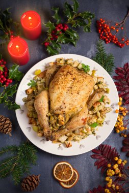 Elmalı ekmek ve kereviz ile doldurulmuş kızarmış tavuk. Noel Şükran Günü yemeği masası. Üst görünüm, genel görünüm