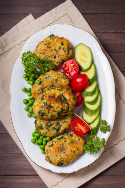 Beyaz tabakta yeşil bezelye ve sebzeli tavuk ıspanaklı burger. Yukarıdan bak, en iyi stüdyo çekimi.