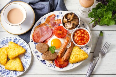Klasik İrlanda ya da İngiliz kahvaltısı. Sosis, pastırma pastırması, puding, fasulye ve ızgara domates. Yüksek açı görünümü