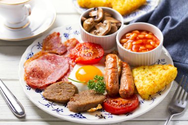Klasik İrlanda ya da İngiliz kahvaltısı. Sosis, pastırma kabuğu, puding, fasulye ve ızgara domates.