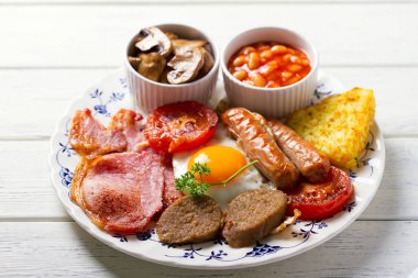 Klasik İrlanda ya da İngiliz kahvaltısı. Sosis, pastırma kabuğu, puding, fasulye ve ızgara domates.