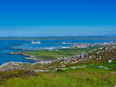 Mavi gökyüzü ile bir yaz gününde Kuzey Galler 'deki Anglesey adasındaki Holyhead limanından İrlanda' ya bir feribot kalkıyor..