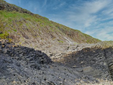 Columnar jointed volcanic basalt rocks in which the vertical joints form polygonal columns, on the island of Staffa in the Inner Hebrides, Scotland, UK