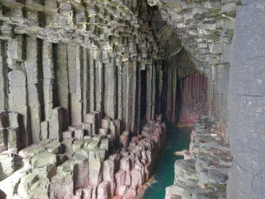 Columnar jointed volcanic basalt rocks in which the vertical joints form polygonal columns, in Fingal's Cave on the island of Staffa in the Inner Hebrides, Scotland, UK clipart
