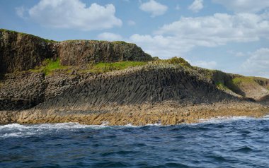 Columnar jointed volcanic basalt rocks in which the vertical joints form polygonal columns, on the island of Staffa in the Inner Hebrides, Scotland, UK