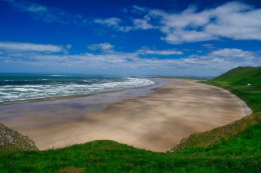 İngiltere 'nin Güney Galler' deki Gower Yarımadası 'ndaki Rhossili Körfezi plajı, yazın güneşli bir gün..