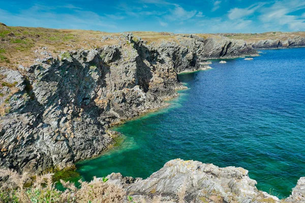 英国威尔士英格利岛崎岖多石的海岸线 悬崖峭壁映衬着蔚蓝的大海 在一个阳光灿烂的夏日 蓝天在夏天 — 图库照片