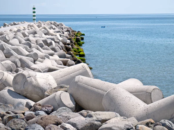 A pier of tetrapod concrete sea defences in Funchal, Madeira showing the form of the tetrapods in the foreground and the pier stretching into the distance