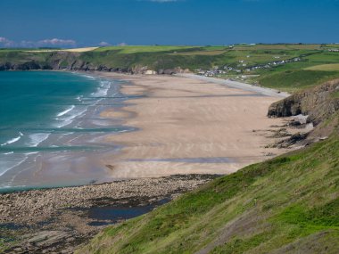 Newgale Sahili, Pembrokeshire. Yazın Sahil Yolu 'ndan mavi gökyüzüne karşı çekilmiş.