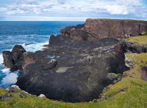 Coast rock formations at Eshaness on Shetland, Scotland, UK - the rocks are of the Eshaness Volcanic Formation - andesite, augite - igneous bedrock formed approximately 383 to 393 million years ago in the Devonian Period. The local environment was pr