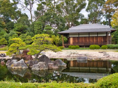 Geleneksel bir Japon evi ve küçük bir göl, manikürlü bahçesi ve küçük ağaçları var.