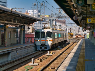Kasım ayının güneşli bir sabahında Nagoya İstasyonu 'ndaki boş bir platformda modern, yerel, elektrikli bir banliyö treni..