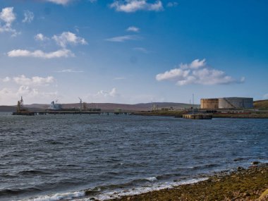 İngiltere 'nin Shetland kentindeki Sullom Voe Petrol Terminali' nde petrol tankeri ve iskelesi. Fabrika, Kuzey Denizi ve Doğu Shetland Havzası 'ndaki İngiltere petrol sahalarının üretimini yürütüyor..