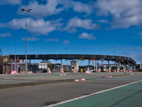 Плаза сбора пошлин на Биркенхед со стороны тоннеля Квинсвэй в Ливерпуль под рекой Мерси, сделанная в солнечный день с голубым небом
