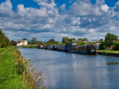 Lancashire 'daki Liverpool Kanalı' nın sessiz ve kırsal bir yerinde demirlemiş bir dizi kanalı daraltan tekne güneşli bir yaz günü çekildi..