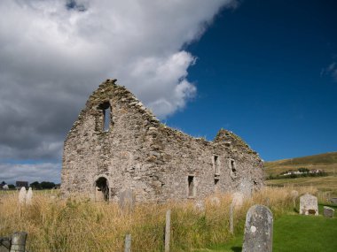 Olnafirth Kirk kalıntıları ve Voe, Shetland 'daki eski mezar taşları.