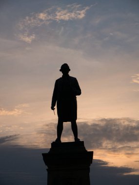 Kuzey Yorkshire, İngiltere 'de bulunan Whitby' de bulunan James Cook 'un bronz heykeli, bir yaz akşamının ilerleyen saatlerinde batan güneşe karşı siluet olarak 2 Ekim 1912 tarihinde açıldı..