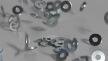 Parlak demir paklar beyaz bir masaya düşer ve yavaş çekimde zıplar. homojen arka plan. 180 fps