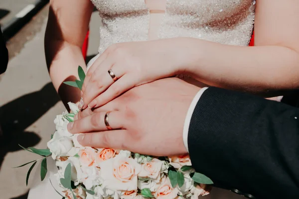 在温暖的夏日里 情人们在阳光下牵着手 在婚礼上散步 新郎用手指触摸婚礼的花束 — 图库照片