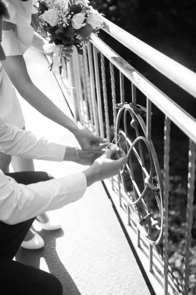 新婚夫妇把铁锁挂在桥的栏杆上 作为永恒爱情的象征 黑白摄影 — 图库照片
