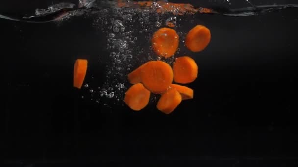 Many Slices Fresh Carrots Fall Water Spray Slowly Sinking Bottom — Stock Video