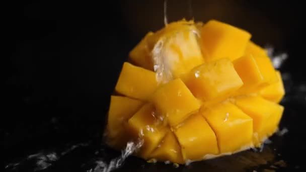 Water Splashes Pours Orange Juicy Diced Mango Black Background Macro — Stock Video