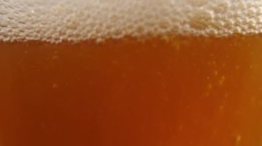 Portakal suyu, köpük ve köpüklü bira kadehe yavaşça dökülür. Stüdyoda makro çekim 180 fps
