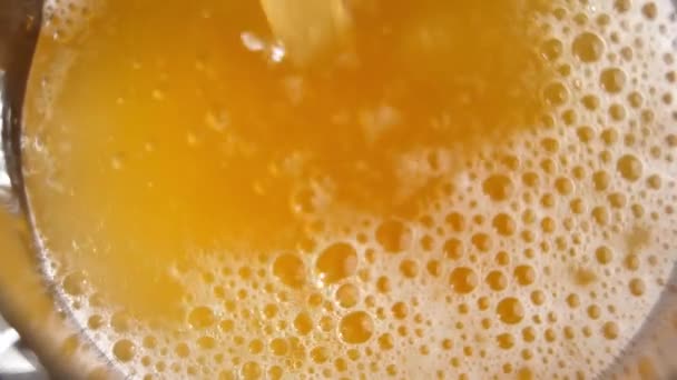 Oranžové Ovocné Pivo Stříkancemi Pěnou Bublinkami Pomalu Nalévá Sklenice Makro — Stock video