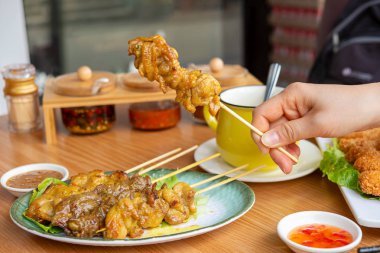 Kadın el satay parçalarını tutar 